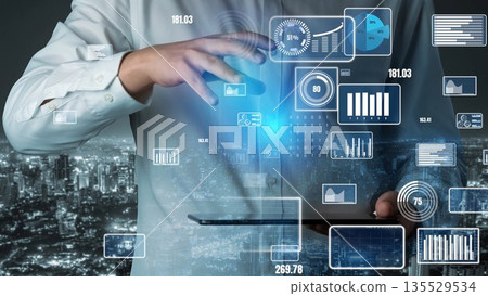 Businessman Interacting with Digital Interface and Data Visualizations Above Tablet in Urban Nightscape with City Lights in Background xenic 135529534