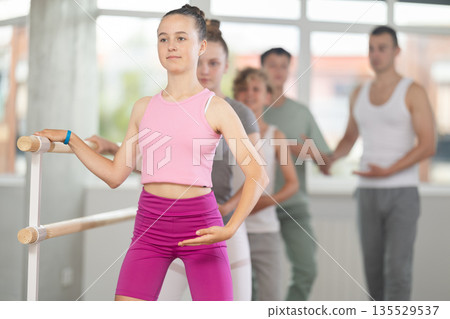 Teenage girl practicing plie position of ballet during choreography classes Teenage girl practicing plie position of ballet during choreography classes 135529537