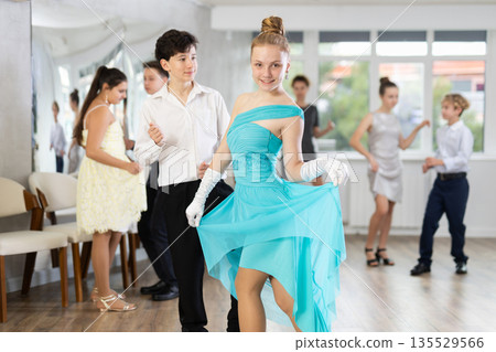 Girl in dress posing in dance studio 135529566