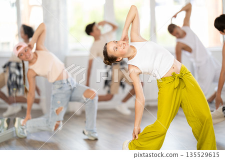 Teenage girl practicing hip-hop backbend moves in training hall Teenage girl practicing hip-hop backbend moves in training hall 135529615