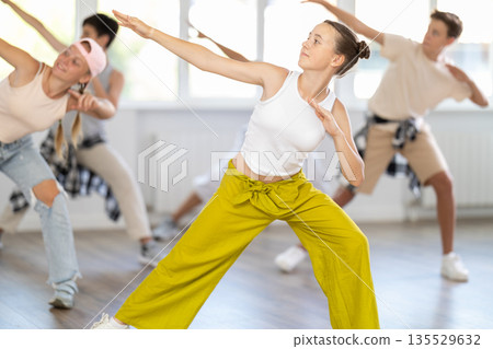 Teenage girl practicing hip-hop dance in training hall 135529632