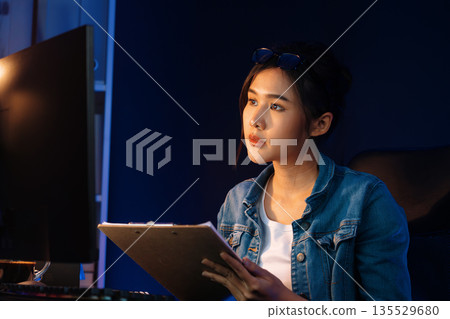 Thinking Asian woman analyzing profit comparing on email report. Stratagem. Thinking Asian woman analyzing profit comparing on email report. Stratagem. 135529680