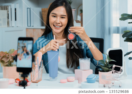 Young Asian reviewing cosmetic makeup brush with pastel color. Stratagem. 135529686