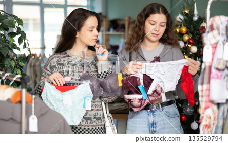 Two women choosing lace lingerie on Christmas tree background 135529794