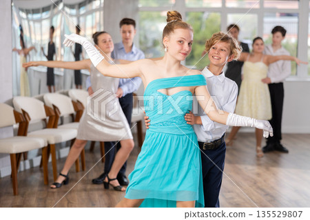 Boy and girl dancing ballroom dance in studio Boy and girl dancing ballroom dance in studio 135529807