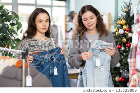 Two young women choosing jeans in store 135529809