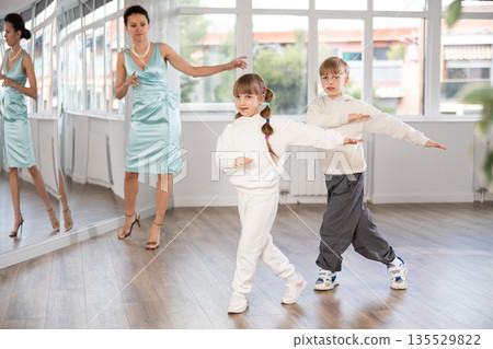 Preteen girl and boy learning moves of lezginka in choreographic studio Preteen girl and boy learning moves of lezginka in choreographic studio 135529822