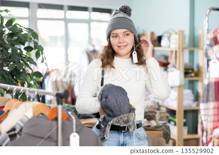 Young woman choosing hat in clothing store 135529902