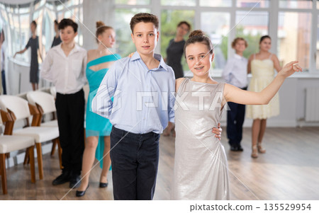 Smiling girls paired with guys dance salsa in dance class 135529954