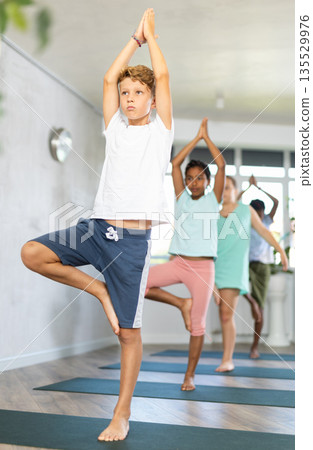 School kids meditating during yoga class 135529976