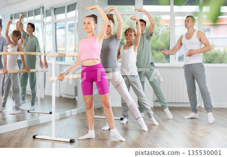 Ballet lesson for teenagers - choreographer teaches girls and boys ballet steps in studio Ballet lesson for teenagers - choreographer teaches girls and boys ballet steps in studio 135530001