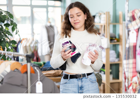 Young woman chooses socks in clothing store 135530032