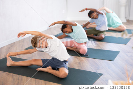 Boy stretches and prepares to perform Jana Shirshasana Boy stretches and prepares to perform Jana Shirshasana 135530138