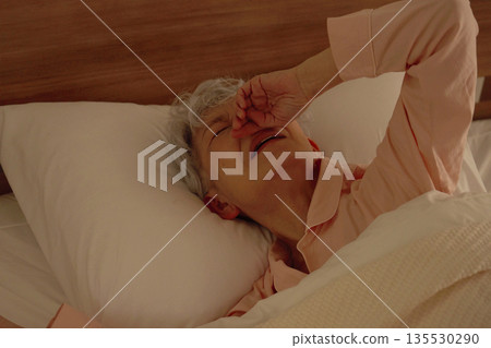 臥室裡，一位鼻塞的老婦人正忍受著鼻塞的痛苦。 135530290