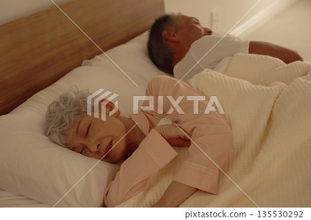 Senior couple sleeping in their bedroom 135530292