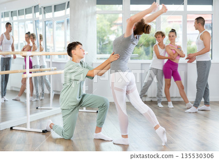 Ballet studio - teenagers girls and boys learn ballet movements in pairs Ballet studio - teenagers girls and boys learn ballet movements in pairs 135530306