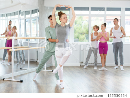 Teenage girl and boy practicing ballet positions in pair in dance studio 135530334