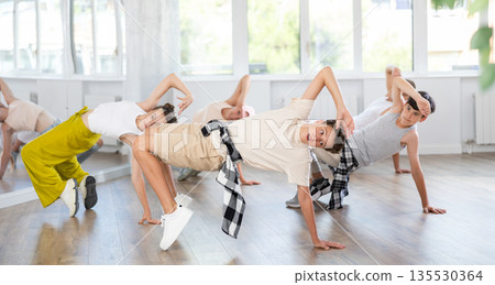 Teenage boy practicing hip-hop floor-works in training hall Teenage boy practicing hip-hop floor-works in training hall 135530364
