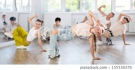 Teenage girl dancing breakdancing in group Teenage girl dancing breakdancing in group 135530370