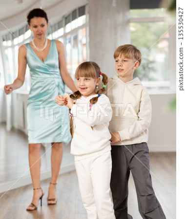 Boy with girl dressed in sport wear train to dance waltz during classes. 135530427