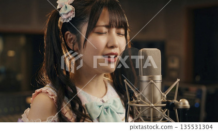 A female idol singing with emotion in a recording studio. 135531304