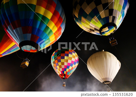 colorful hot air balloons glowing against dark night sky 135531620