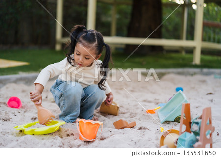 happy child girl playing sand with toy on playground happy child girl playing sand with toy on playground 135531650