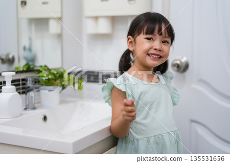 girl child brushing teeth in bathroom girl child brushing teeth in bathroom 135531656
