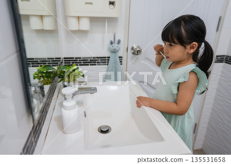 girl child brushing teeth in bathroom girl child brushing teeth in bathroom 135531658