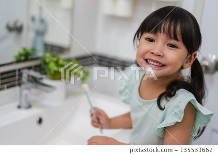 girl child brushing teeth in bathroom girl child brushing teeth in bathroom 135531662