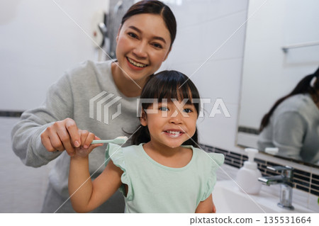 mother teaching girl child to brushing teeth in bathroom mother teaching girl child to brushing teeth in bathroom 135531664