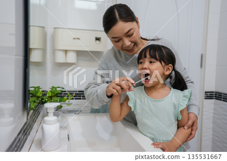 mother teaching girl child to brushing teeth in bathroom mother teaching girl child to brushing teeth in bathroom 135531667