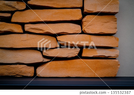 Natural stone wall with warm tones in contemporary interior setting 135532387