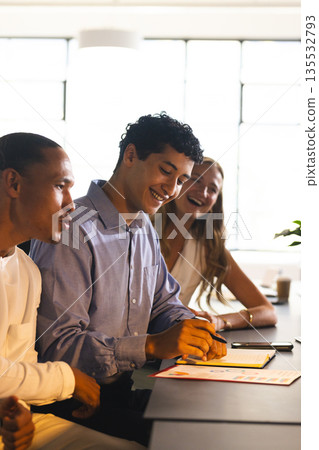 Colleagues collaborating at office, smiling and discussing ideas during meeting Colleagues collaborating at office, smiling and discussing ideas during meeting 135532793