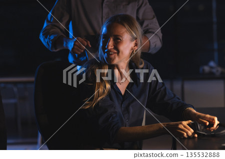Businesswoman smiling while working late at office, engaging in conversation Businesswoman smiling while working late at office, engaging in conversation 135532888