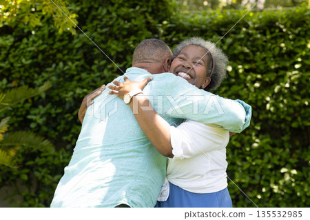 Senior couple embracing joyfully in garden, sharing warm and happy moment 135532985
