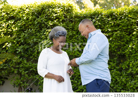 African American senior couple enjoying joyful moment together in garden 135533028