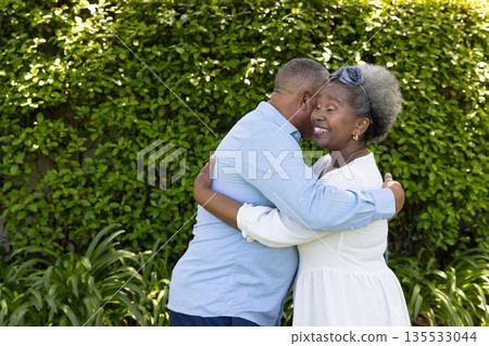 Senior couple embracing warmly in garden, enjoying joyful moment together 135533044