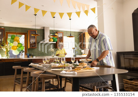 Senior couple preparing festive table in kitchen, enjoying celebration together 135533154
