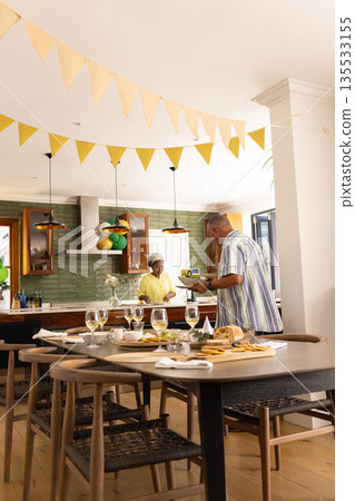 Senior couple preparing festive meal in modern kitchen, enjoying togetherness Senior couple preparing festive meal in modern kitchen, enjoying togetherness 135533155