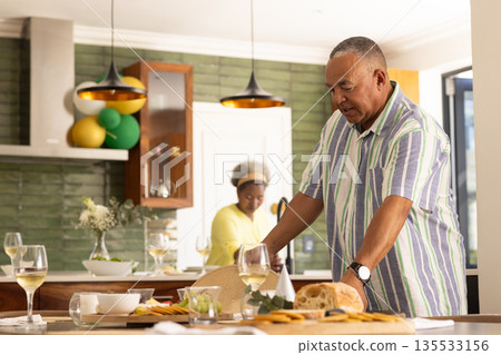Senior couple preparing meal together in modern kitchen, enjoying quality time Senior couple preparing meal together in modern kitchen, enjoying quality time 135533156
