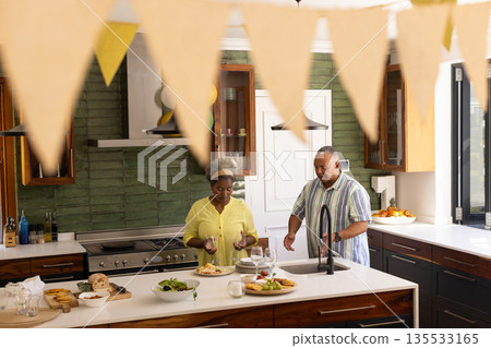 Senior couple preparing meal together in modern kitchen, enjoying quality time 135533165