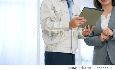 A worker explaining using a tablet in the office A worker explaining using a tablet in the office 135533307