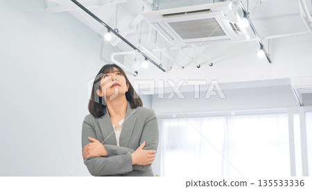 A female business person freezing in the office A female business person freezing in the office 135533336