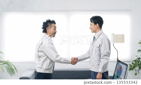 Group of workers shaking hands in an office Group of workers shaking hands in an office 135533342