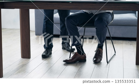一群商務人士在辦公室開會，他們的腳在鏡頭前。 135533351