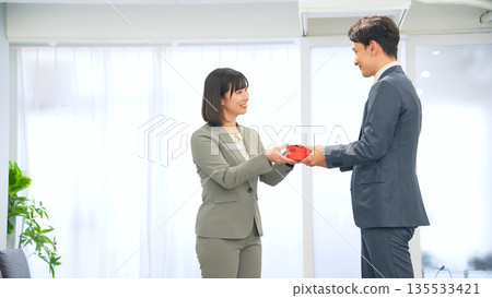 Business people giving gifts in the office 135533421