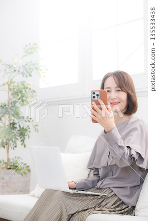 老年女性使用智慧型手機進行臉部識別 135533438