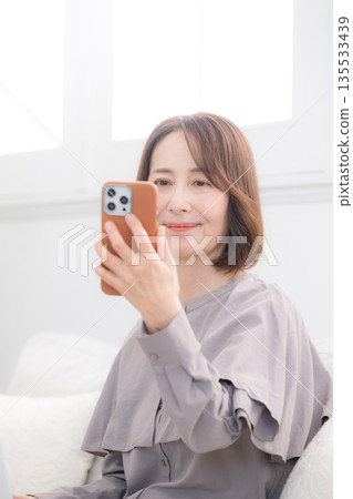 老年女性使用智慧型手機進行臉部識別 135533439