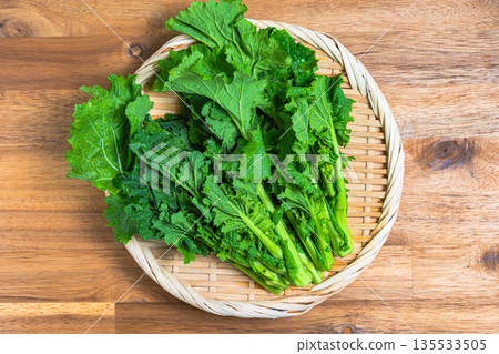 A bunch of rape blossoms arranged on a bamboo basket. Spring vegetable ingredients A bunch of rape blossoms arranged on a bamboo basket. Spring vegetable ingredients 135533505